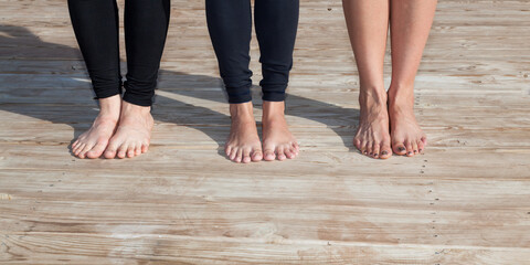 Three Sets of Feet on Yoga Platform