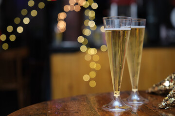 Glasses of champagne on a table, lights blurred background. Christmas party concept.