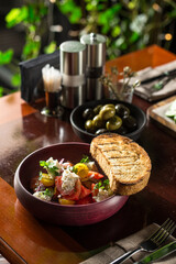 salad with fresh vegetables and cottage cheese in bowl and bread toast on wooden table