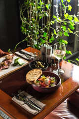 salad with fresh vegetables and cottage cheese in bowl and bread toast on wooden table