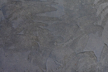 Grungy uneven dark gray textured natural cement background.