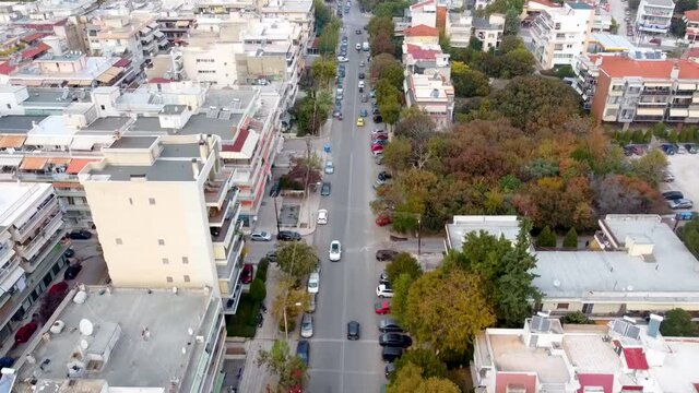 Aerial view of urban environment in the city of Thessaloniki, Greece, east side, road with cars, backward movement  by drone 