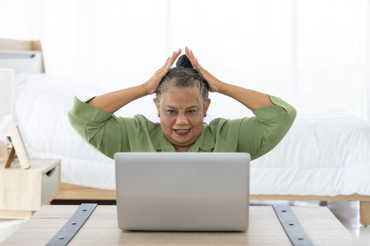 Senior Woman Touching Forehead And Looking At Laptop Computer Screen, She's Forgot Or Missing Something