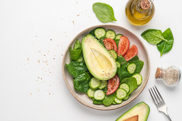 Avocado vegetables salad with spinach. Vegan healthy diet. White background with copy space