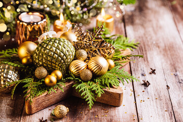 Christmas composition with fir branches, Christmas decorations and candles on wooden background.