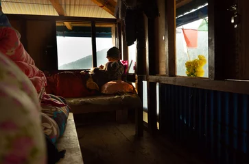 Papier Peint photo Makalu un homme et une femme sont allongés sur le lit et s& 39 embrassent, et à l& 39 extérieur de la fenêtre, vous pouvez voir des montagnes et des drapeaux himalayens. Parc national de Makalu Barun, Himalaya, Népal