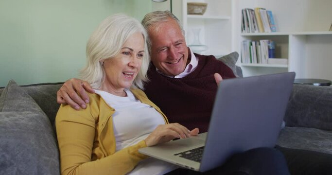 Happy senior caucasian couple making video call using laptop computer
