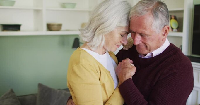 Happy senior caucasian couple embracing and slow dancing togther