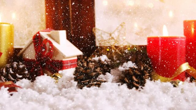 Animation of snow falling over christmas decoration with pine cones