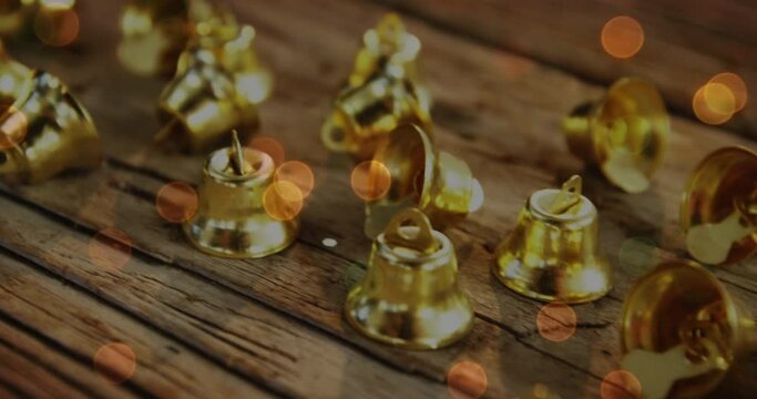 Animation of christmas gold bells on rustic wooden background