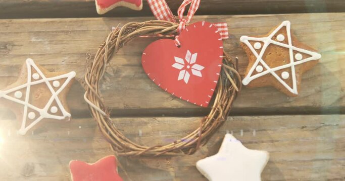 Animation of traditional gingerbread cookies and christmas decoration on wooden background