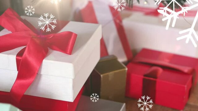 Animation of multiple snowflakes falling over christmas presents in the the background