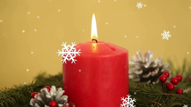 Animation of christmas candle and decoration with snowflakes falling