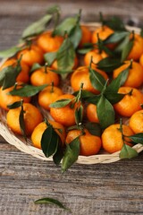 Juicy tangerines with green leaves on a wooden table 