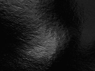 Black foil background with highlights and uneven texture