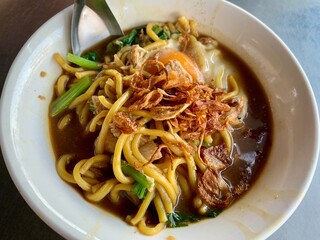 close-up Thai Chinese traditional Hokkien noodles soup in white bowl