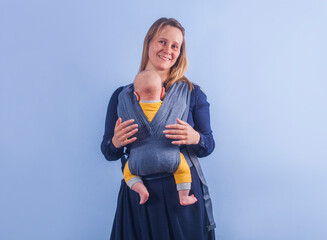 Baby in sling on mom on blue background