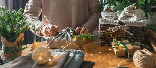 Christmas gifts. New year and gift wrapping, zero waste furoshiki, eco friendly gift wrapping in kraft paper on eco christmas background, eco christmas holiday concept, banner with eco decor