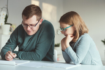 Young father at home office teaching his daughter during quarantine lockdown