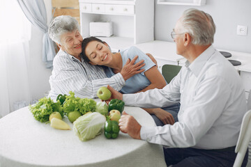 Family in a kitchen. Grandparents with granddaughter. Family made a salad