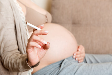 Pregnant woman with cigarette at home. mother smoking concept
