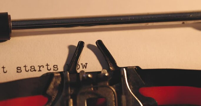 Writing message It starts now to indicate the beginning of something using a vintage typewriter