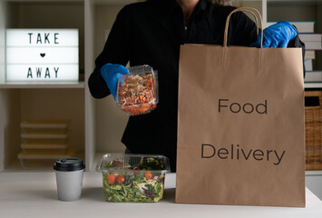 Food on small containers to take away on a paper bag. Food delivery concept