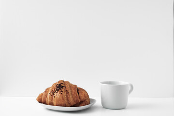 White mug and croissants on a white background. Eco-friendly and natural materials in the decor, dessert. Copy space, mock up
