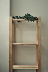 Green eucalyptus branches lie on a wooden rack. Interior decoration.Eco-materials, storage. Folk