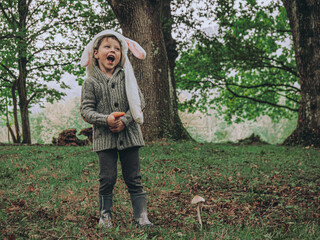 ADORABLE NIÑO FELIZ VESTIDO DE CONEJO EN EL BOSQUE