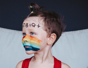 un niño libre de estereotipos con los colores del arcoiris en la cara simbolo de LGTBIQ+