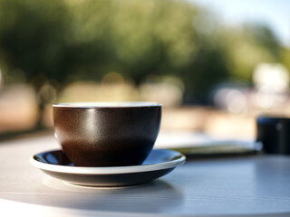 Tasty coffee. Close up of cup of coffee on the table on a daytime outdoors. Selective focus. Horizontal shot