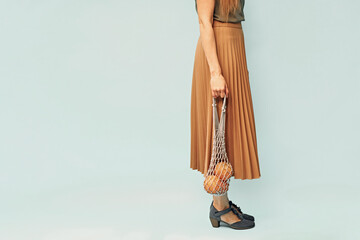 Girl with a string bag in her hands. Eco bag in the hands of the girl. Eco-friendly packaging.