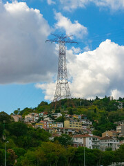 Electric power line post and high-voltage lines above houses on hill in Istanbul, Turkey