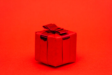 Gift box with a bow isolated on redbackground for new year or christmas 