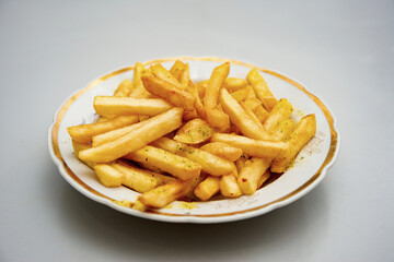 The finished fries are on a plate sprinkled with seasoning.