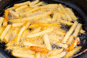 Fry fries in hot oil in a pan.