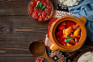 Baked meat in a clay pot, or a traditional pot dish, a stew with vegetables and meat cooked in the oven. Turkish and balkan or oriental food platter, flat lay with copy space