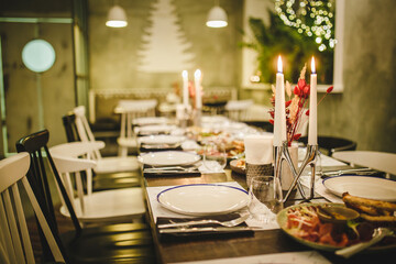 luxurious night dinner atmosphere in the restaurant. olive color design dining room. candles and snow-white dishes crockery