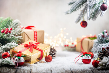 Christmas red decorations on snow with gift boxes, fir tree branches and christmas lights. Winter Decoration Background with copy space for text