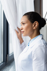African american doctor looking at window in clinic