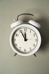 alarm clock with a dial lies on a gray background