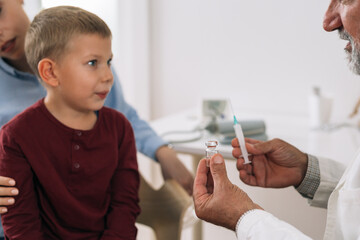 mother with her child receives coronavirus vaccine at the doctor office