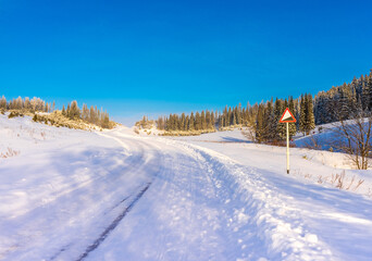Fototapeta premium Winter road leading to the top of the hill. Russia, Udmurtia