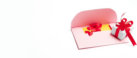Valentine's Day. Pink an envelopes with small cut paper heart and gift box with red bow. Writing a love letter. Message.Top view.Valentine concept. copy space. White background