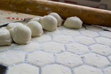 Close-up of dumplings on the background of a rolling pin. Handmade dumplings.