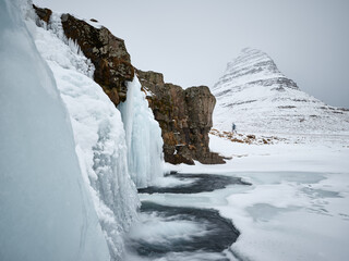 Kirkjufellsfoss waterfall in winter. Mount Kirkjufell in background. Snæfellsnes Peninsula, West Iceland.