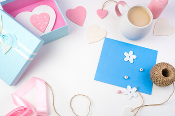 Hearts, blue envelope and gift box on a light background. Top view with space to copy. The concept of Valentine's day.