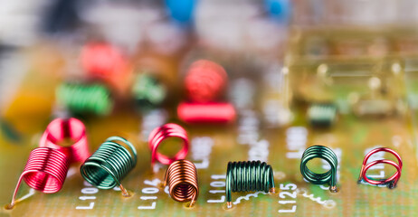 Electromagnetic air-core inductors for high frequencies on circuit board panoramic background....