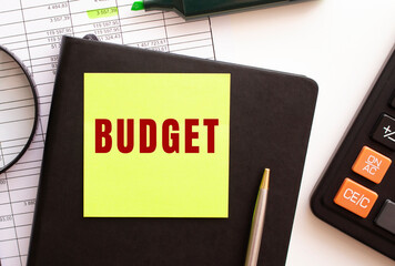 BUDGET text on a sticker on your desktop. Diary, calculator and pen.